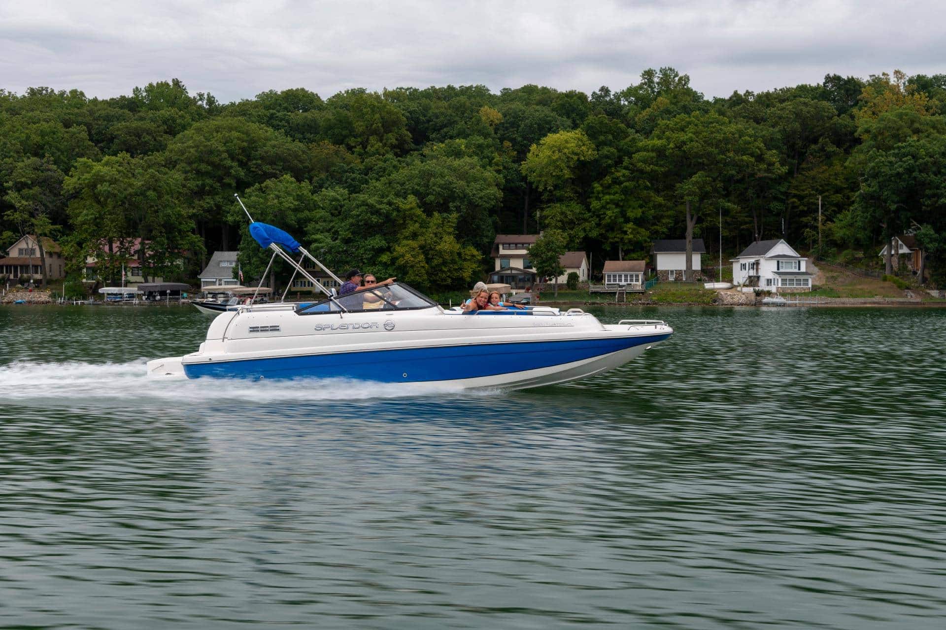 One of Splendor's catamaran deck boats speeding across the surface of a lake.